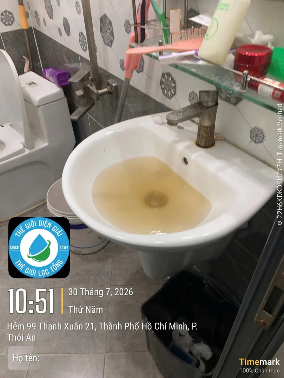 Chậu hứng nước từ vòi lavabo trước khi làm sạch đường ống — nước đục, ngả vàng
